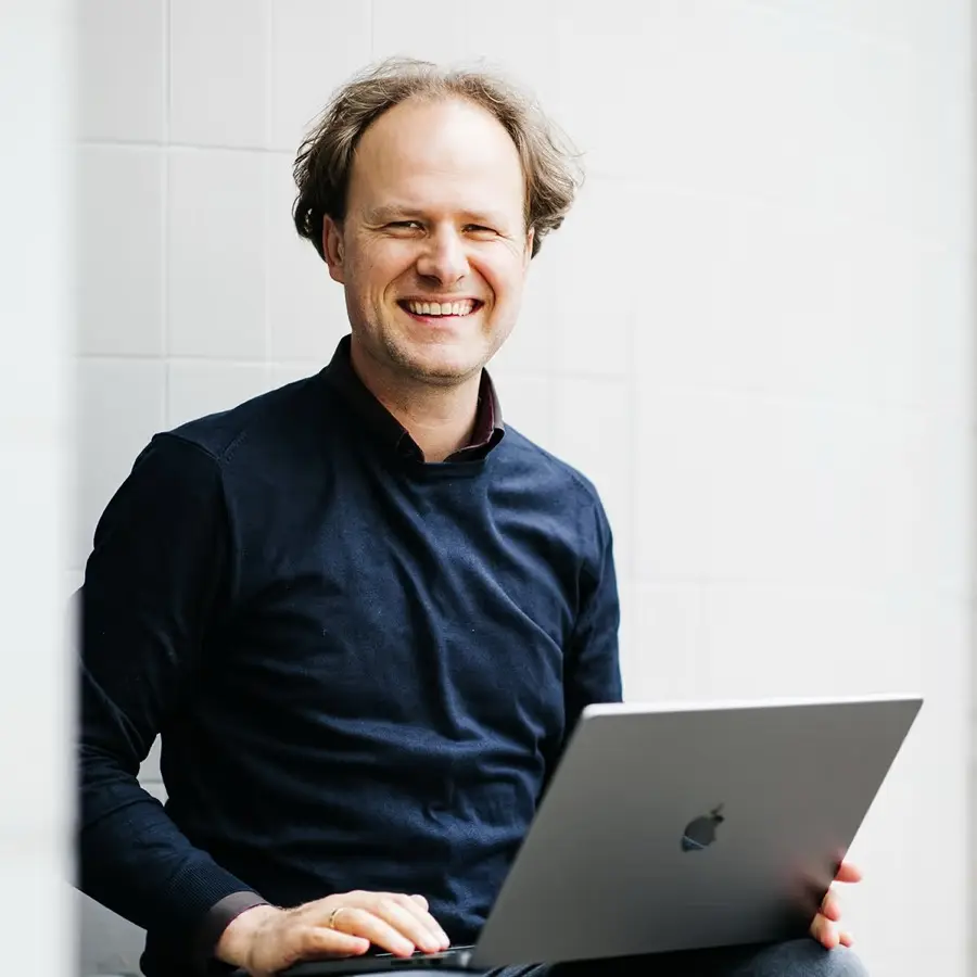 Hans van der Klok, lachend, met zijn laptop